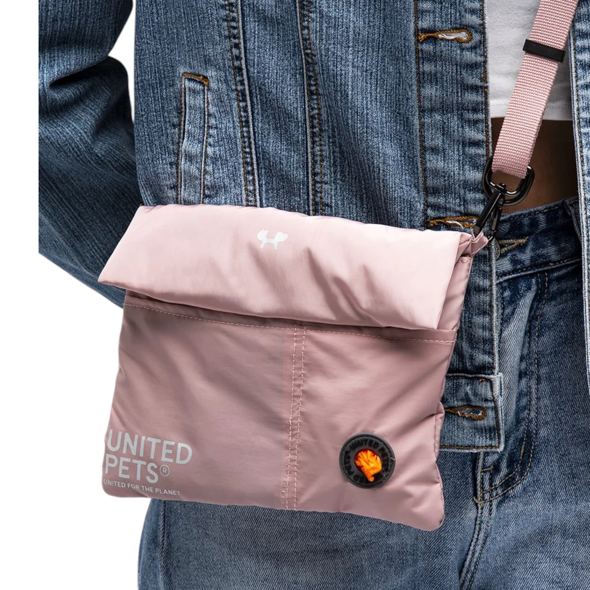 Dettaglio della borsa CityLife rosa di United Pets indossata a tracolla, con tasca portasacchetti
