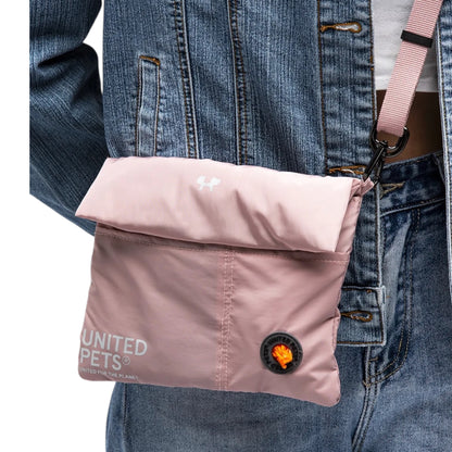 Dettaglio della borsa CityLife rosa di United Pets indossata a tracolla, con tasca portasacchetti